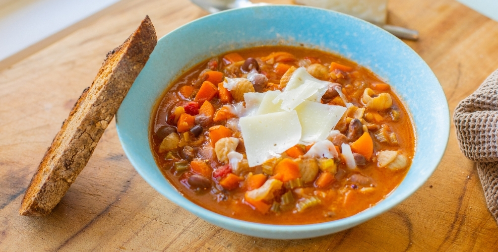 Warm minestrone soup in a bowl with toast